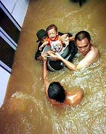 An Indonesian child cries during an evacuation from his house in a flooded area