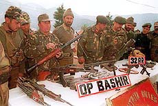 Army jawans displaying arms and ammunition recovered from five foreign militants 