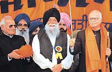 Union Home Minister L.K. Advani (extreme right ) holds a sword presented by SAD general secretary Kanwaljit Singh (centre) at an election rally in Rajpura on Thursday.