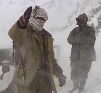 An armed Afghan man directs rescue operation