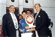 DDCA Sports Secretary Sunil Dev presenting the first Chaudhary Nahar Singh Vir Singh Saini Cricket Trophy to Salwan Boys captain Tarun Chowdhary.