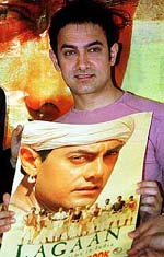 Aamir Khan poses with a copy of film-based comic of his Hindi film Lagaan in Mumbai.