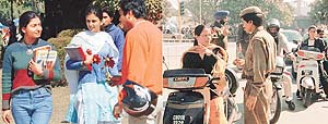 A boy comes up to a girl with flowers on the Panjab University campus, Chandigarh, on Thursday, even as policemen conduct security checks 