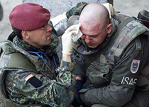 A German soldier receives medical attention after being hit by a rock during the event.