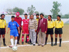 Delhi Police captain Jagya Ram Boro kick-starts the DSA Super League, watched by DSA president Umesh Sood (in red cap)and joint secretary Narinder Kumar Bhatia (fifth from right) at the Ambedkar Stadium in the Capital on Sunday.