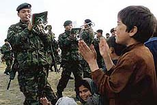 Afghan children clap along as British Gurkhas in a military band play in Kabul