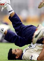 Saurav Ganguly does stretching exercises during a practice session.