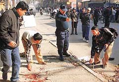 The Nepalese police inspects an area of a bomb explosion