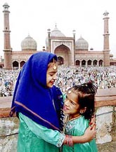 Two girls greet each other on the occasion of Id-ul-Zuha at Jama Masjid in New Delhi on Saturday. 