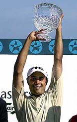 India's Arjun Atwal poses with the Singapore Masters trophy after winning the golf tournament 