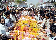 Local residents surround bodies covered in traditional garments