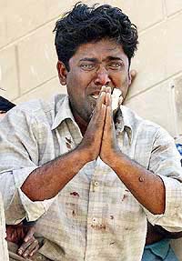 A Muslim man stranded on the first floor of his house and surrounded by Hindu rioters begs to nearby policemen to rescue him in Ahmedabad on Friday.