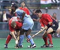 India's Baljit Singh Dhillon (C) runs into England's Bill Waugh (L)