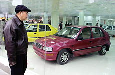 A Chinese man looks at new cars