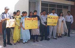 Students hold placards while protesting against the authorities of DAV College