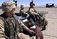 US army soldiers carry a badly injured prisoner