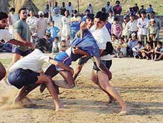 Dadu Majra players attempt to hold Gurmeet of Kajheri village during a kabaddi match of the Rural Sports Tournament at Dadu Majra on Friday.