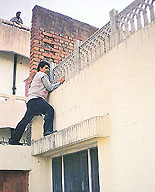 A CBI official climbs a wall of the house of the UT Assistant Excise Taxation Commissioner, S.P. Kansal, during a raid in Parwanoo on Saturday.