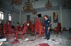 A police officer stands inside a church in Islamabad after two attackers hurled grenades 