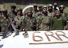 Army personnel display arms and ammunition recovered from four foreign militants 