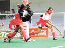 Jasjeet Kaur of Haryana dodging Neena (goalkeeper) of Madhya Pradesh during the 51st Senior Womens National Hockey Championship in Jalandhar on Tuesday.