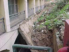 A recently constructed retaining wall collapses at the back of the HP Government Secretariat Armsdale building on Wednesday.