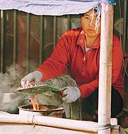 A woman at a market in Beilin village near Guiyu in China's southern Guangdong province cleans a computer circuit board to retrieve components, creating an acrid stench in the air.