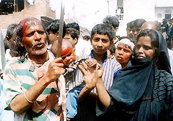 A Shiite Muslim couple hold their son with cut on forehead during the religious rite of Ashoura as part of Muharram in Lucknow on Monday.