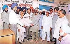 A poster asking farmers to bring dried and cleaned wheat to mandis being released at a farmers awareness programme organised by the Food and Supplies Department at Jagraon Mandi in Ludhiana district on Tuesday.