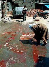 A woman washes the road of blood