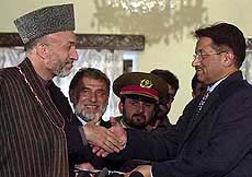 Afghanistan Interim Prime Minister Hamid Karzai, left, shakes hands with Pakistan President General Pervez Musharraf