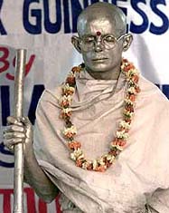 Akchinthala Sheshu Babu, 31, dressed as a statue of Mahatma Gandhi