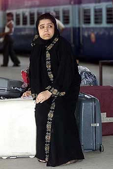 A woman waits for a train on a railway platform