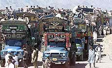 Scores of trucks loaded with Afghan refugee families prepare to return them home