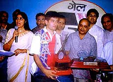 Sachin Ratti, who upset world number 10 Pullela Gopichand in the final of the Hari Chand Memorial All-India Badminton Tournament, receives the winner's trophy in Kanpur 