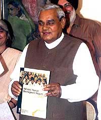 Prime Minister Atal Behari Vajpayee shows a copy of the National Human Development Report