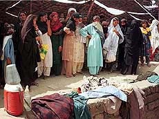 Pakistani women try to identify relatives' belongings