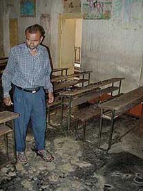 A school trustee examines the burnt remains