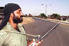 A BSF jawan keeps a vigil at the curfew-bound Vejalpur road 
