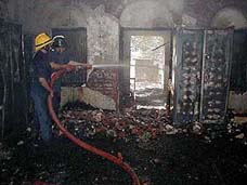 Fire brigade personnel douse the fire