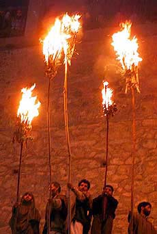 Kashmiri villagers hold torches