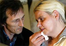 Brian Pretty wipes the face of his wife, Dianne during a news conference in London