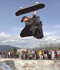 A skateboarder loses his board while performing stunts