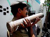 A Policemen carrying a crude rocket seized during searching in Danilimda area of Ahmedabad on Monday. 