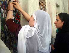 A woman ties a thread at the popular shrine