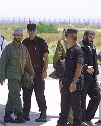 Two Palestinian militants (L and R) are escorted from a British military aircraft