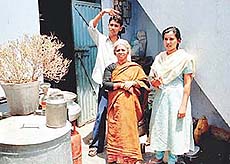 Three members of the Dubey family who were attacked by their landlords. Their belongings, that were thrown out of the house, lie scattered near the only room that they presently occupy.
