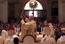 The Pope's special envoy to the Holy Land Cardinal Roger Echegarai (R) holds an icon of the Virgin Mary at the Church of Nativity in Bethlehem on Sunday during the first Catholic mass held after the five-week standoff.