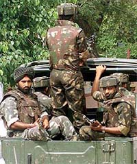 Armed Indian soldiers patrol a street
