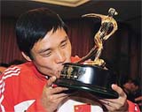 Chinese national player Fan Zhiyi kisses his trophy 